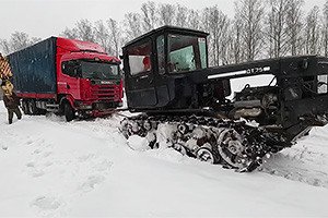 (VIDEO) Cum sună un tractor cu motor V8 de Lexus, cu şenile, care tractează un camion Scania prin zăpadă în Rusia
