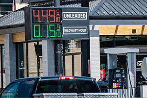 O staţie de alimentare nou construită din SUA afişează preţuri comparative la panou pentru benzină şi electricitate, într-o nouă normalitate