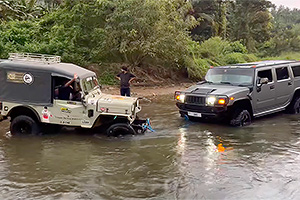 (VIDEO) Un offroader mic de demult se dovedeşte a fi mai capabil decât un Hummer şi-l tractează pe acesta dintr-un râu