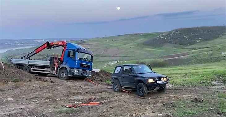 (VIDEO) Un micuţ Mitsubishi Pajero Pinin tractează un ditamai camion MAN cu macara, blocat în noroi în Moldova