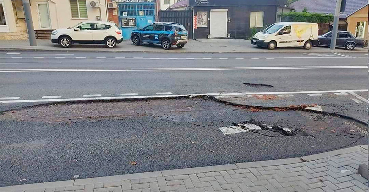 Strada Ion Creangă din Chişinău, recent reparată capital, a rămas fără porţiuni de asfalt în urma furtunii, de după care se văd plase