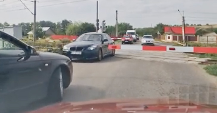 (VIDEO) Semafoarele roşii şi barierele de la o trecere de cale ferată din Răcăciuni, România, ignorate de 9 şoferi şi 2 biciclişti în nici două minute