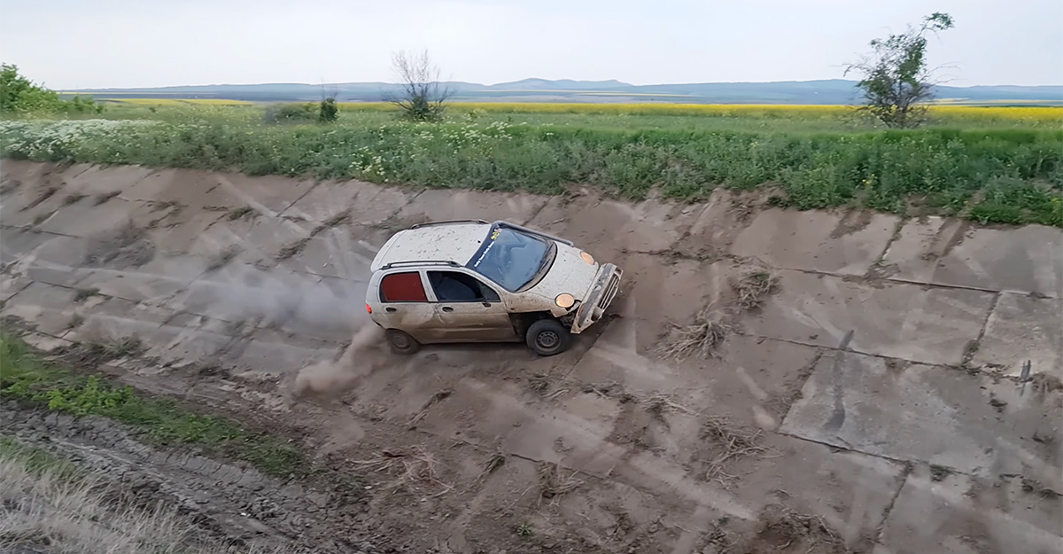 (VIDEO) Un Daewoo Matiz reuşeşte să treacă un canal abrupt în România, fiind condus fără milă de proprietarul său